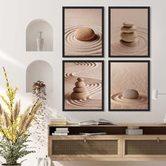 three framed pictures hanging on the wall above a wooden table with vases and plants