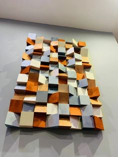 a large wooden sculpture sitting on top of a gray table next to a white wall