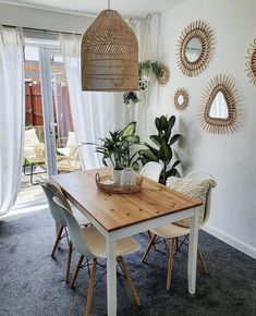 a dining room table and chairs with plants on the wall