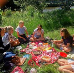 a group of women sitting on the ground eating food