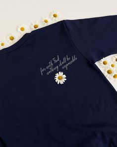 a blue t - shirt with daisies on it