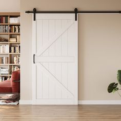 a living room with an open sliding barn door and bookshelf in the background