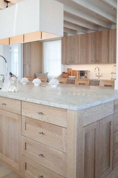 a large kitchen with wooden cabinets and marble counter tops