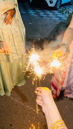 two people holding sparklers in their hands