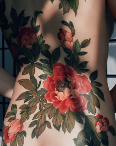 the back of a woman's body with flowers painted on her stomach and side