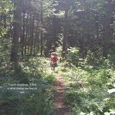 two people walking down a path in the middle of a forest with words written on it