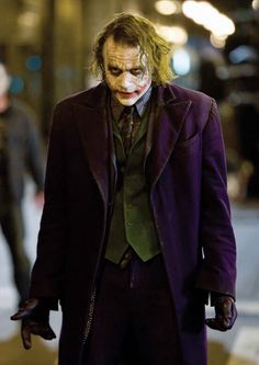 the joker is walking down the street at night