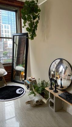 a living room with a large mirror and plants on the floor in front of it