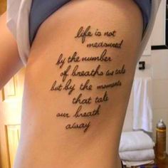 a woman with a tattoo on her back saying life is not measured by the number of inches