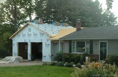 a house under construction with the roof ripped off and insulation taped to it's side