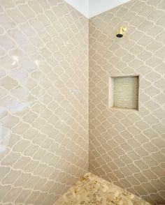 a bathroom with a toilet and shower head in the corner, next to a tiled wall