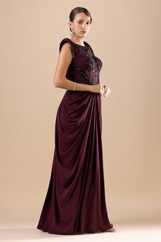 Wine padded bodice draped dress with crystal, cutdana, sequins, and Swarovski embroidery on the bodice. - Aza Fashions Festive Evening Dress With Draped Design, Pre-draped Embellished Sleeveless Dress, Sequin Draped Wedding Dress, Sequined Draped Dress For Wedding, Sequin Draped Dress For Reception, Pre-draped Reception Dresses, Embellished Draped Dress For Gala, Party Dresses With Pre-draped Traditional Shape, Pre-draped Traditional Dresses For Party