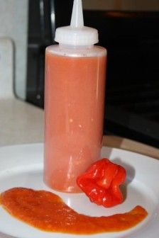 a bottle of sauce and some red peppers on a plate