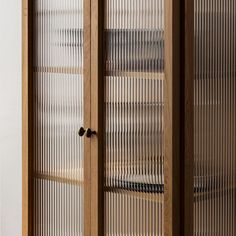 a tall wooden cabinet with glass doors