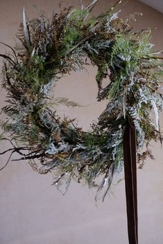 a close up of a wreath on top of a pole with snow and grass around it