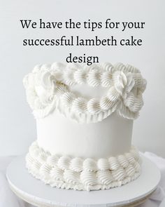 a white cake sitting on top of a table next to a sign that says, we have the tips for your successful lambeth cake design