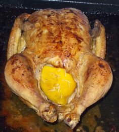 a cooked chicken sitting on top of a pan covered in gravy and seasoning