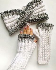 three pairs of white knitted gloves with silver beading on the wrist and fingers