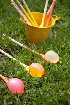 two buckets filled with eggs sitting in the grass next to an orange and white cup