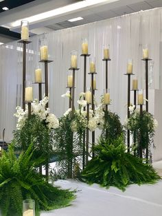 several tall candles and flowers are on display