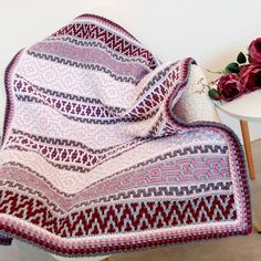 a blanket is draped over a table with flowers on it