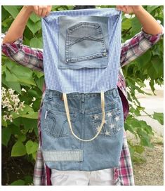 a person holding up an old pair of jeans to their face with both hands and one eye open