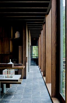 the long hallway is lined with wooden walls and benches on either side of the room