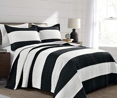 a bed with black and white bedspread in a room