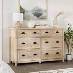 a dresser with drawers and vases on top of it in a room that has white walls