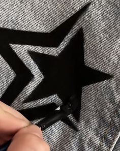 someone is cutting out a black star on a piece of fabric