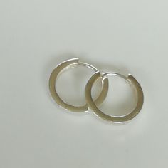 Thick band ear hoops made of sterling silver with a hinged joint. Dimensions: 16 X 2.5 mm Weight: 2.3 gm Price listed is for a pair of hoops. These earrings are made of 925 hypoallergenic sterling silver. All my pieces are sent in a gift box. I can include a personal message from you if needed. You are welcome to contact me at... bhavnakwintra1956@gmail.com More hoops: https://www.etsy.com/your/shops/TheSilverGame/tools/listings/section:26305414 More earrings: https://www.etsy.com/your/shops/The Everyday Silver Metal Huggie Earrings, Minimalist White Gold Huggie Earrings, Minimalist Metal Round Huggie Earrings, Minimalist Round Metal Huggie Earrings, Minimalist Nickel-free Small Hoop Huggie Earrings, Minimalist Metal Hoop Earrings For Everyday, Minimalist Small Hoop Clip-on Earrings, Minimalist Small Hoop Earrings In Metal, Minimalist Small Hoop Metal Earrings