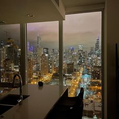 a kitchen with a view of the city lights from it's high rise window