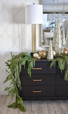 christmas decorations on top of a dresser in front of a mirror