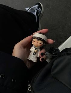 a person holding a small doll in their hand