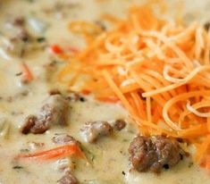 a close up of a bowl of soup with carrots and meat