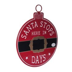 a red ornament that says santa stops here in days