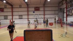 some people are playing volleyball in an indoor court