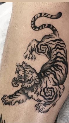 a black and white tiger tattoo on the leg