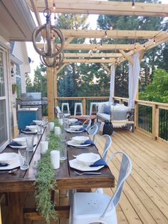 a wooden deck with white chairs and table set for four on it's side