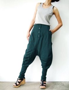 "* ALL ORDERS ARE SHIPPED VIA DHL EXPEDITED MAIL * Cotton jersey harem pants feature a drop crotch design with tapered pant legs, pleated front detail, side seam pockets, elastic back waistband, ribbed cuffs and four tucks at inseam create volume through leg. Roll up the ribbed cuffs hem for an utlra relaxed look! * Pull-on style * decorative pleats front and buttons detailed * Elastic back waistband provides a personal fit * Four tucks at inseam * Side seam pockets * Wide ribbed cuffs Measureme Green Cotton Pants With Buttons, Green Bottoms With Buttons For Fall, Green Fall Bottoms With Buttons, Full-length Cotton Bottoms With Buttons, Full Length Cotton Bottoms With Buttons, Baggy Tapered Pants With Button Closure, Casual Green Pants With Buttons, Fall Bottoms With Buttons And Tapered Leg, Fall Season Bottoms With Buttons And Tapered Leg