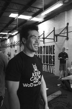 a man smiling while standing in a gym