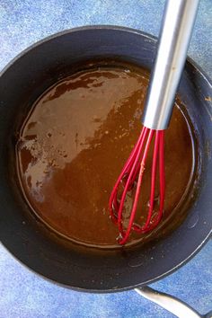 a whisk in a pan filled with melted chocolate