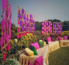 the tables are decorated with bright pink and purple decorations for an outdoor party or wedding