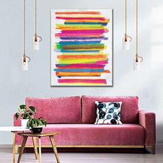 a living room with a pink couch and colorful painting on the wall above it's coffee table