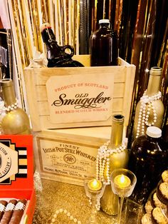 a table topped with lots of wine bottles and boxes filled with chocolate covered donuts