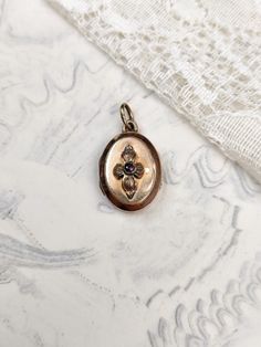 A lovely little antique oval rose gold-plated locket, dating from the turn of the last century, with a rose paste stone in the centre of a flower in relief. The locket is in relatively good antique condition overall, with however several signs of wear consistent with its age. The plating is missing in places, both on the front and back of the jewel. There are a few surface scratches and some verdigris in places, as well as two small indentations on the back. The locket closes well. Dimensions: approx. 1.4 x 2.1 cm. Please note that the locket may appear larger in the photos. Colours may vary depending on the light. The exact colour of the jewel does not show up perfectly in the photos. Rose Gold Vintage Charm Locket Necklace For Wedding, Elegant Rose Gold Locket Necklace With Vintage Charm, Vintage Rose Gold Oval Locket Necklace, Antique Rose Gold Cameo Jewelry, Antique Rose Gold Locket Necklace, Victorian Engraved Rose Gold Locket Necklace, Victorian Rose Gold Locket Necklace, Victorian Rose Gold Locket Jewelry, Antique Rose Gold Jewelry With Vintage Charm