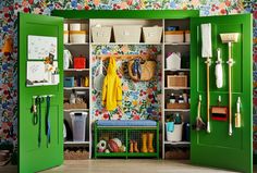 a green closet filled with lots of clutter next to a wall covered in flowers