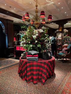 a table covered with red and black checkered cloths next to a chandelier