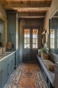 a long hallway with blue cabinets and wooden ceiling, along with an area rug on the floor