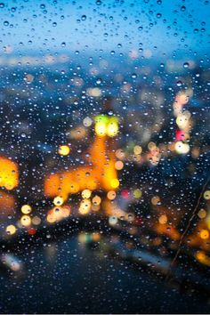 rain drops on a window with city lights in the background